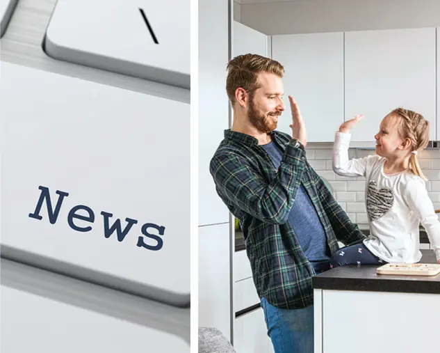 Vater und Tochter geben sich ein High Five in einer modernen Küche mit heller Küchenfront, die Familienfreundlichkeit, Lebensfreude und den Alltag in einer offenen Wohnküche zeigt.